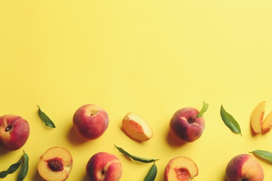 Photo of Fresh ripe peaches and green leaves on yellow background, flat lay. Space for text