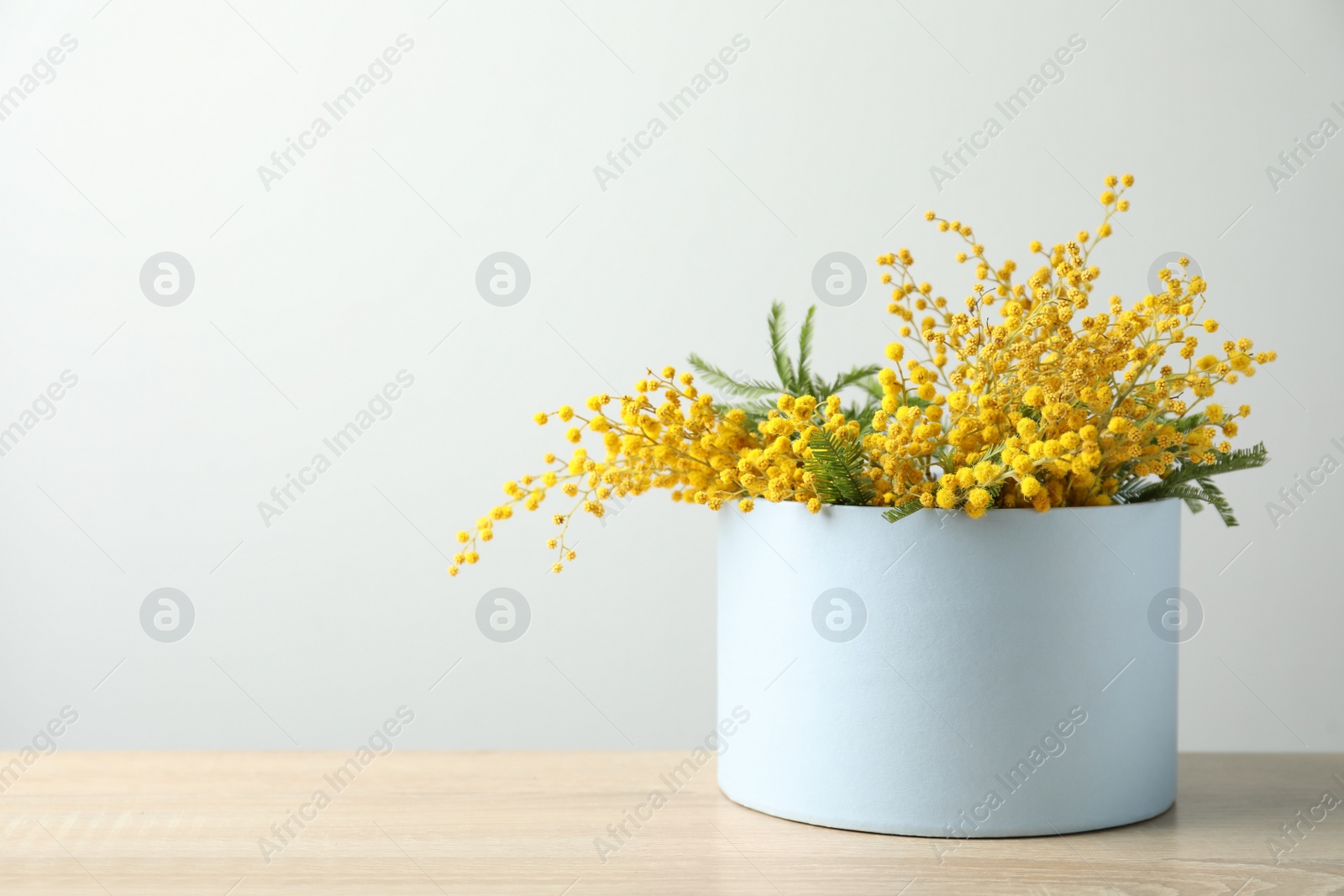 Photo of Bouquet of beautiful mimosa flowers on wooden table