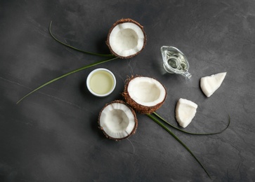 Flat lay composition with natural organic oil and coconuts on grey stone background, flat lay