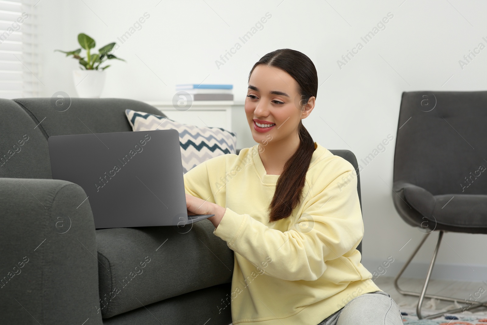 Photo of Woman using laptop on couch at home