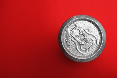 Wet closed can on red background, top view. Space for text