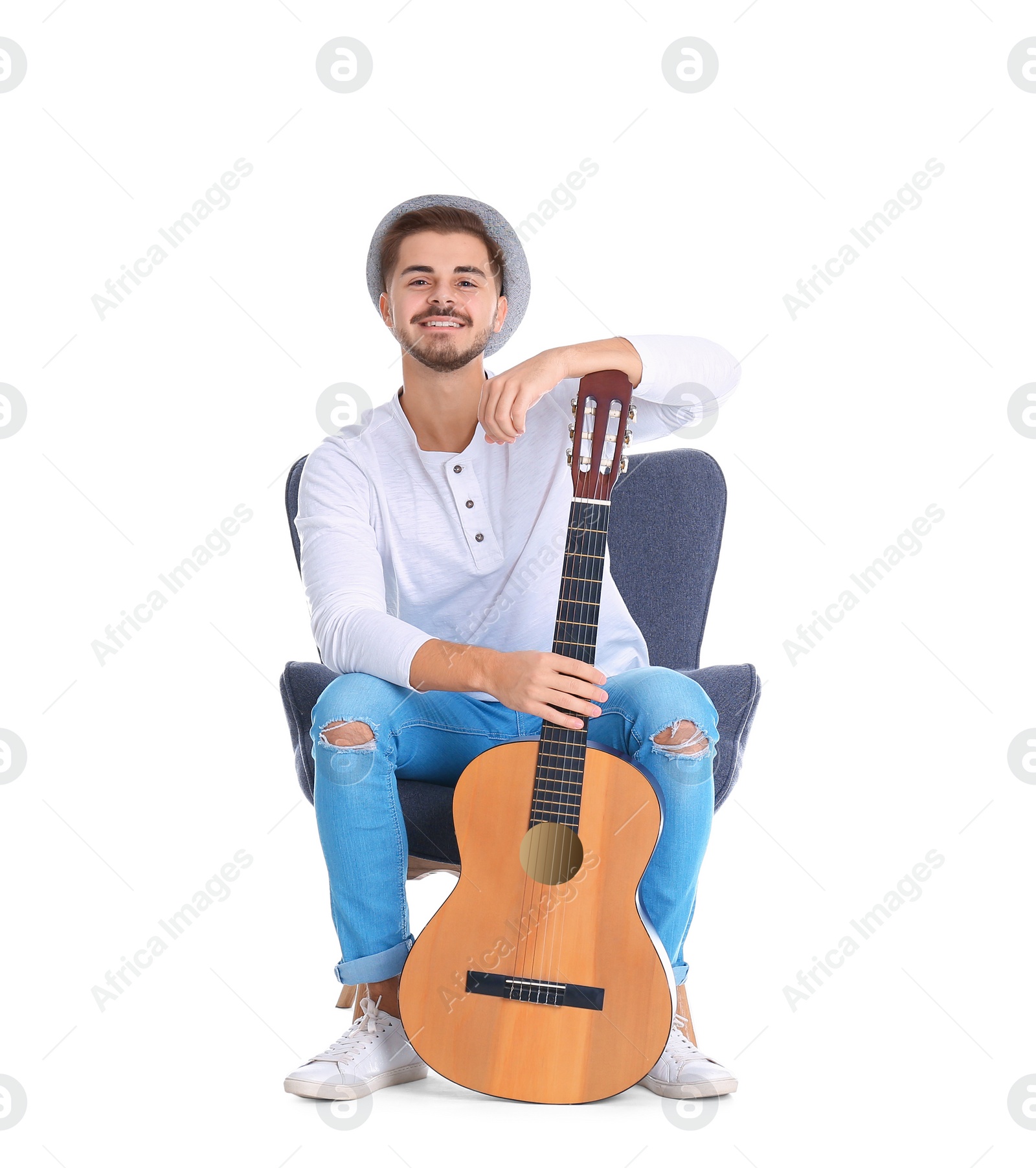 Photo of Handsome young man with guitar in armchair on white background