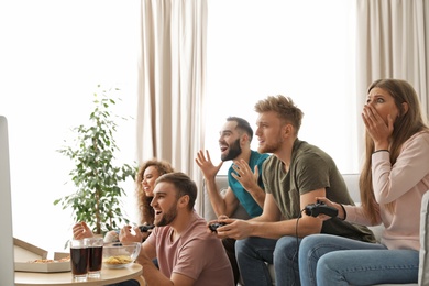 Emotional friends playing video games at home