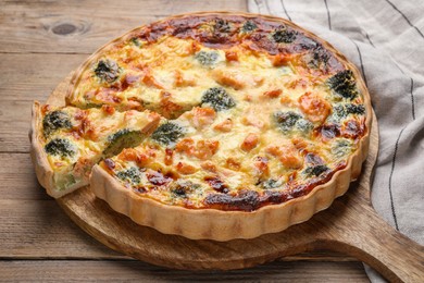 Pieces of delicious homemade quiche with salmon and broccoli on wooden board