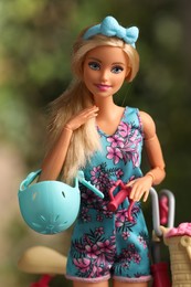 Photo of Mykolaiv, Ukraine - September 4, 2023: Beautiful Barbie doll with helmet and bicycle on blurred background