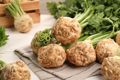 Photo of Fresh raw celery roots on white wooden table