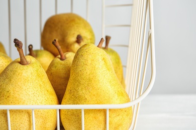 Photo of Basket with fresh ripe pears on light background, closeup view