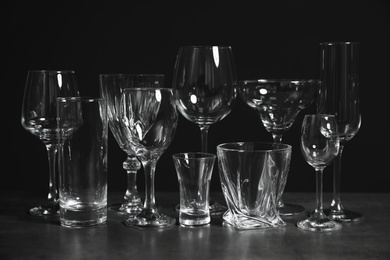 Photo of Set of bar glassware on table against dark background