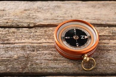Photo of One compass on wooden table, space for text