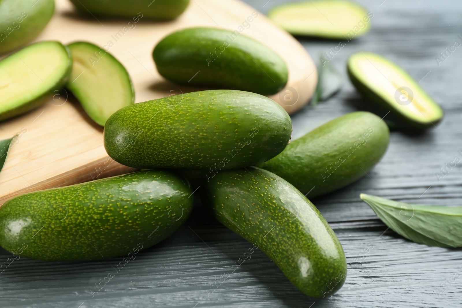 Photo of Fresh seedless avocados on grey wooden table, closeup