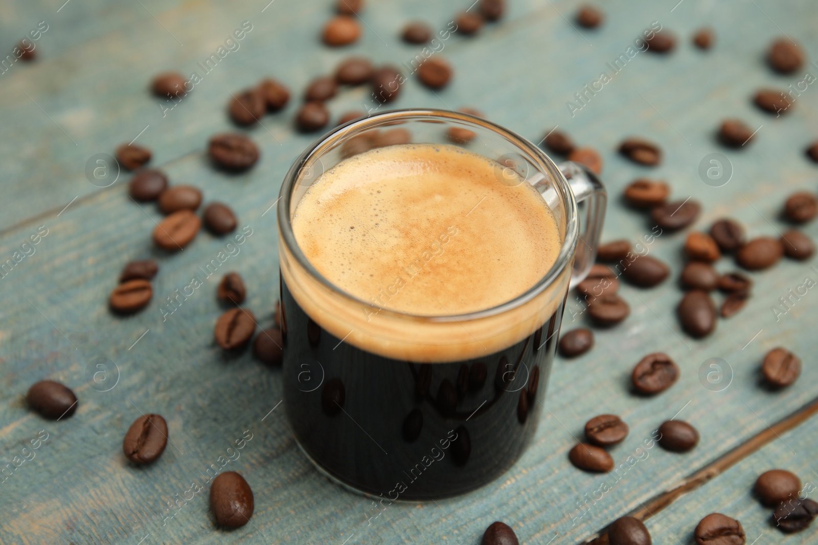 Photo of Cup of tasty coffee on blue wooden table