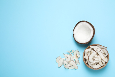 Flat lay composition with tasty coconut chips on light blue background. Space for text