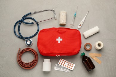 First aid kit on grey table, flat lay