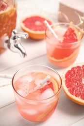 Delicious refreshing lemonade with grapefruit slices on white wooden table