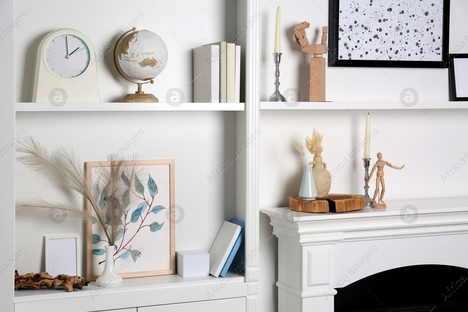 Photo of White shelves with books, globe and different decor indoors. Interior design