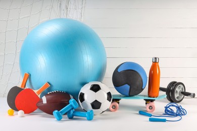 Photo of Many different sports equipment on white table