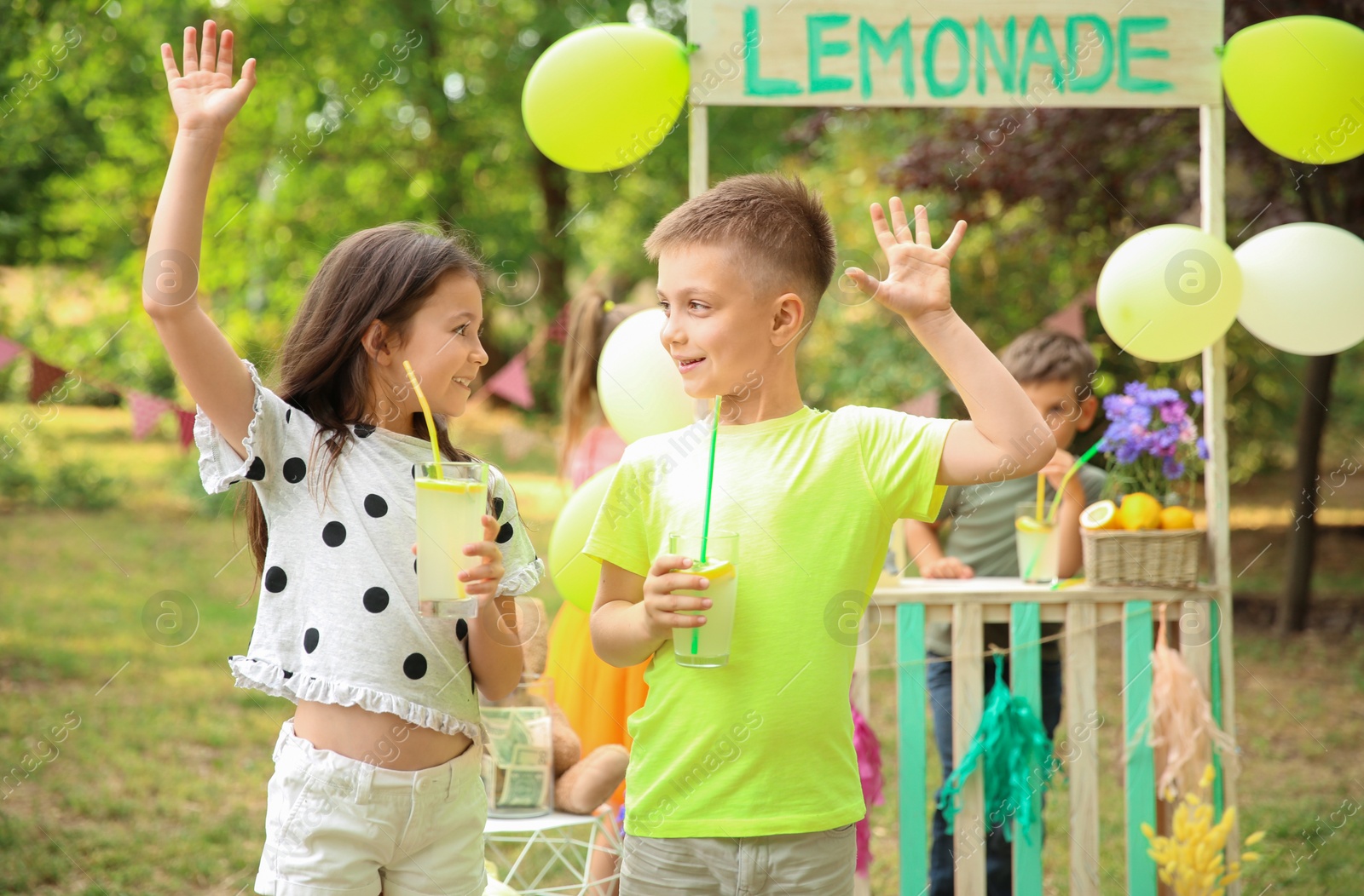 Photo of Little children with natural lemonade in park