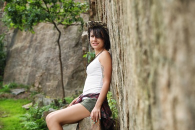 Photo of Young woman near steep cliff on summer day. Camping season