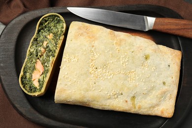 Photo of Delicious strudel with salmon and spinach on table, top view