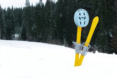 Ski equipment in snow outdoors, space for text. Winter vacation