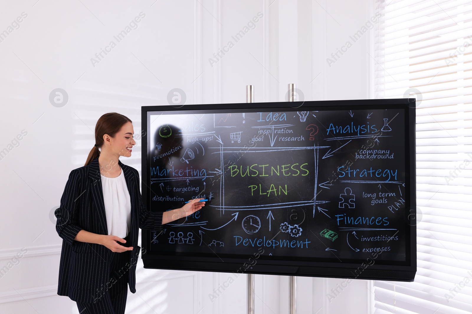 Photo of Business trainer using interactive board in meeting room