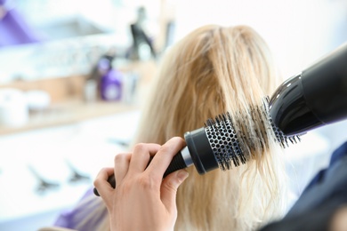 Professional hairdresser working with client in salon