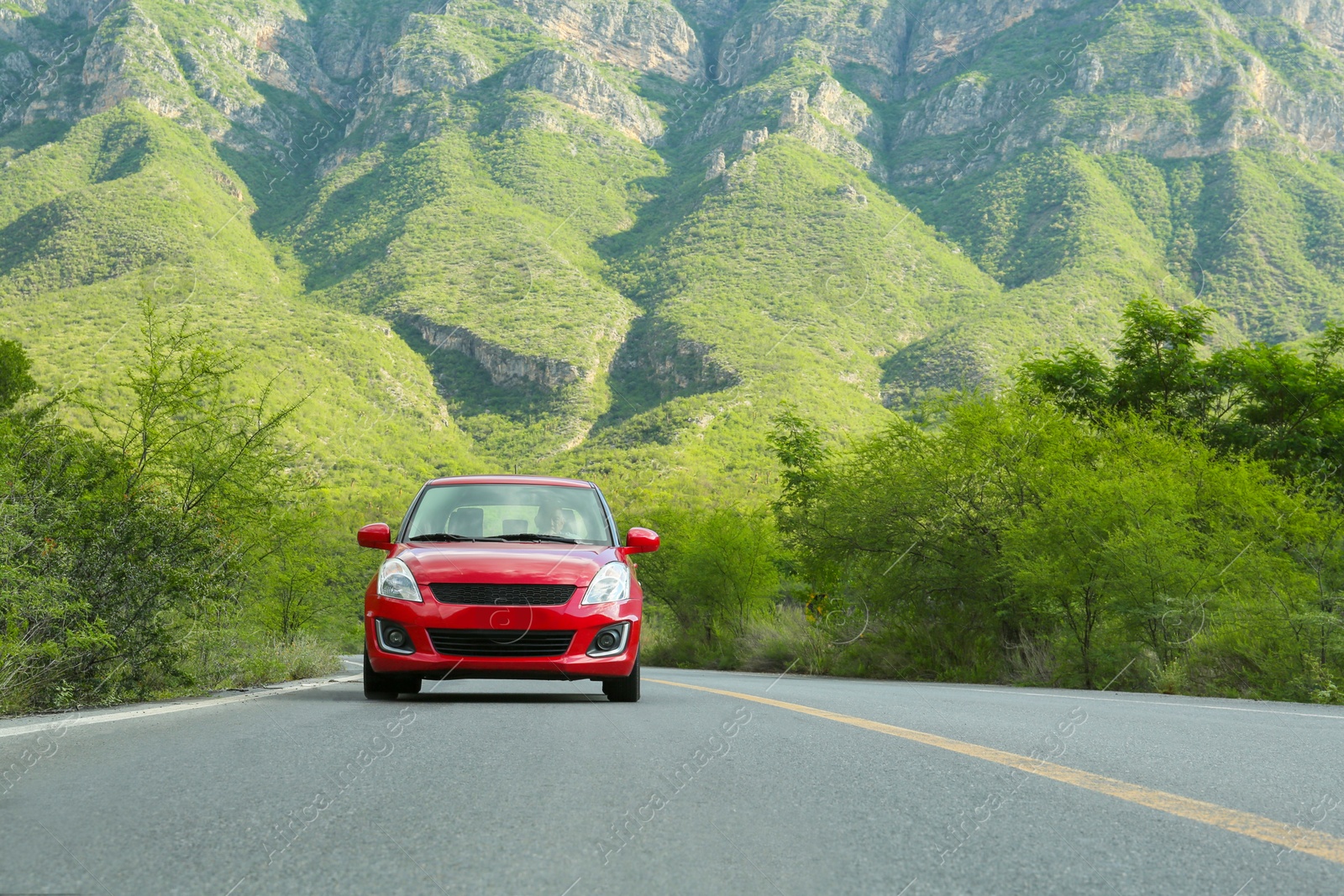 Photo of Beautiful view of car on asphalt highway in mountains. Road trip