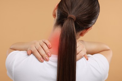 Image of Woman suffering from neck pain on dark beige background, back view