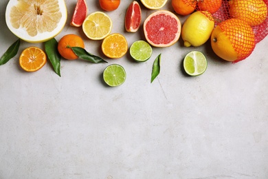 Photo of Different citrus fruits on grey background, top view. Space for text