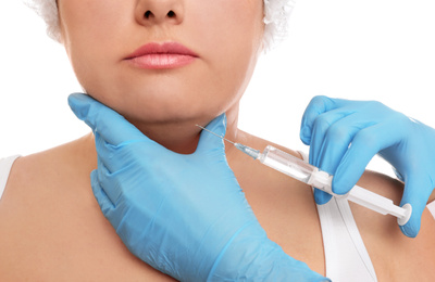 Photo of Woman with double chin getting injection on white background, closeup. Cosmetic surgery