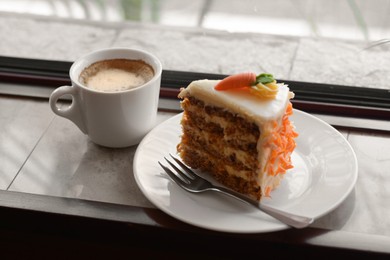 Photo of Delicious cake and cup of hot coffee on windowsill indoors