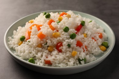 Delicious rice with vegetables on grey table, closeup