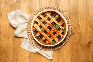 Freshly baked meat pie on wooden table, top view