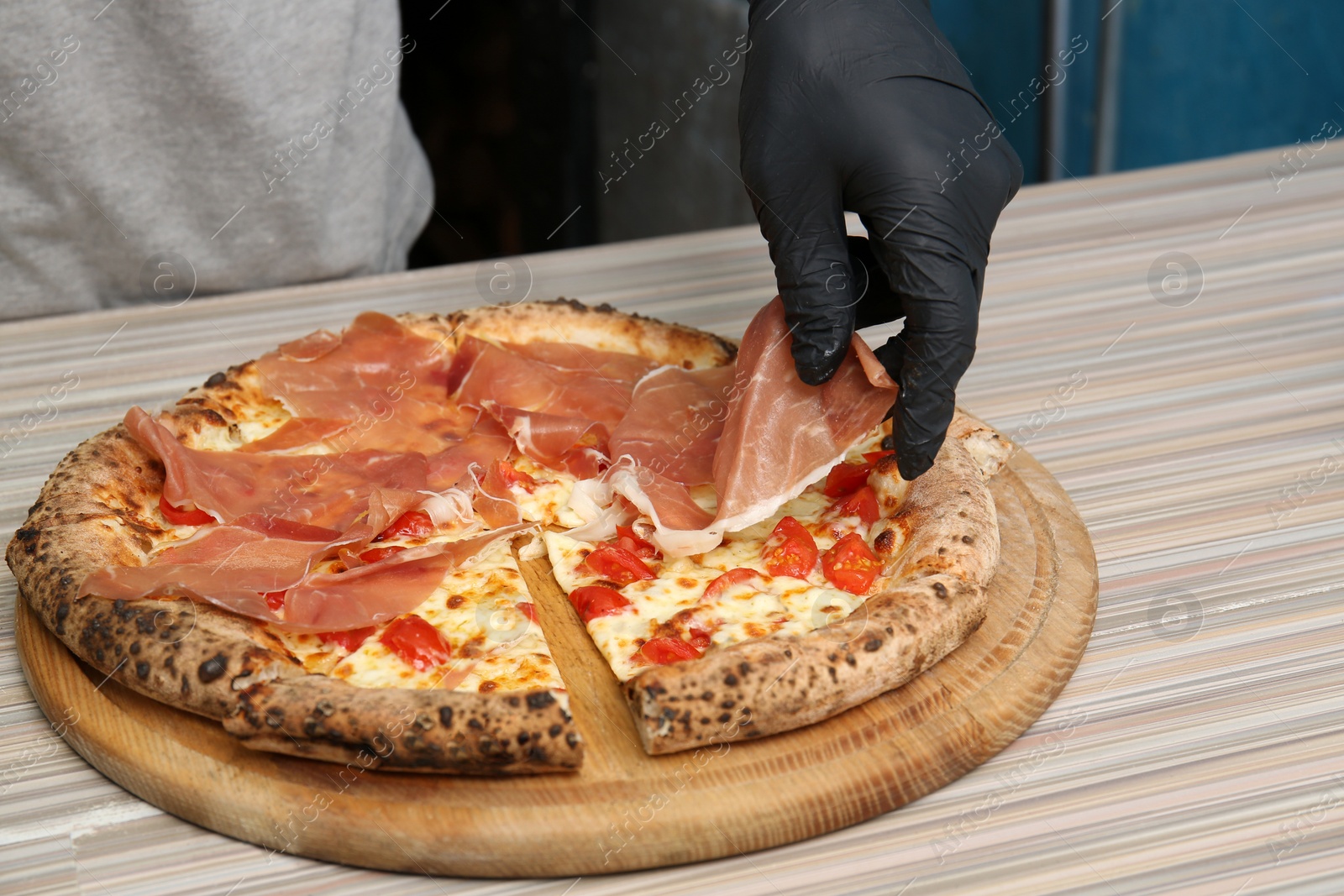 Photo of Professional chef preparing Italian oven baked pizza in restaurant, closeup