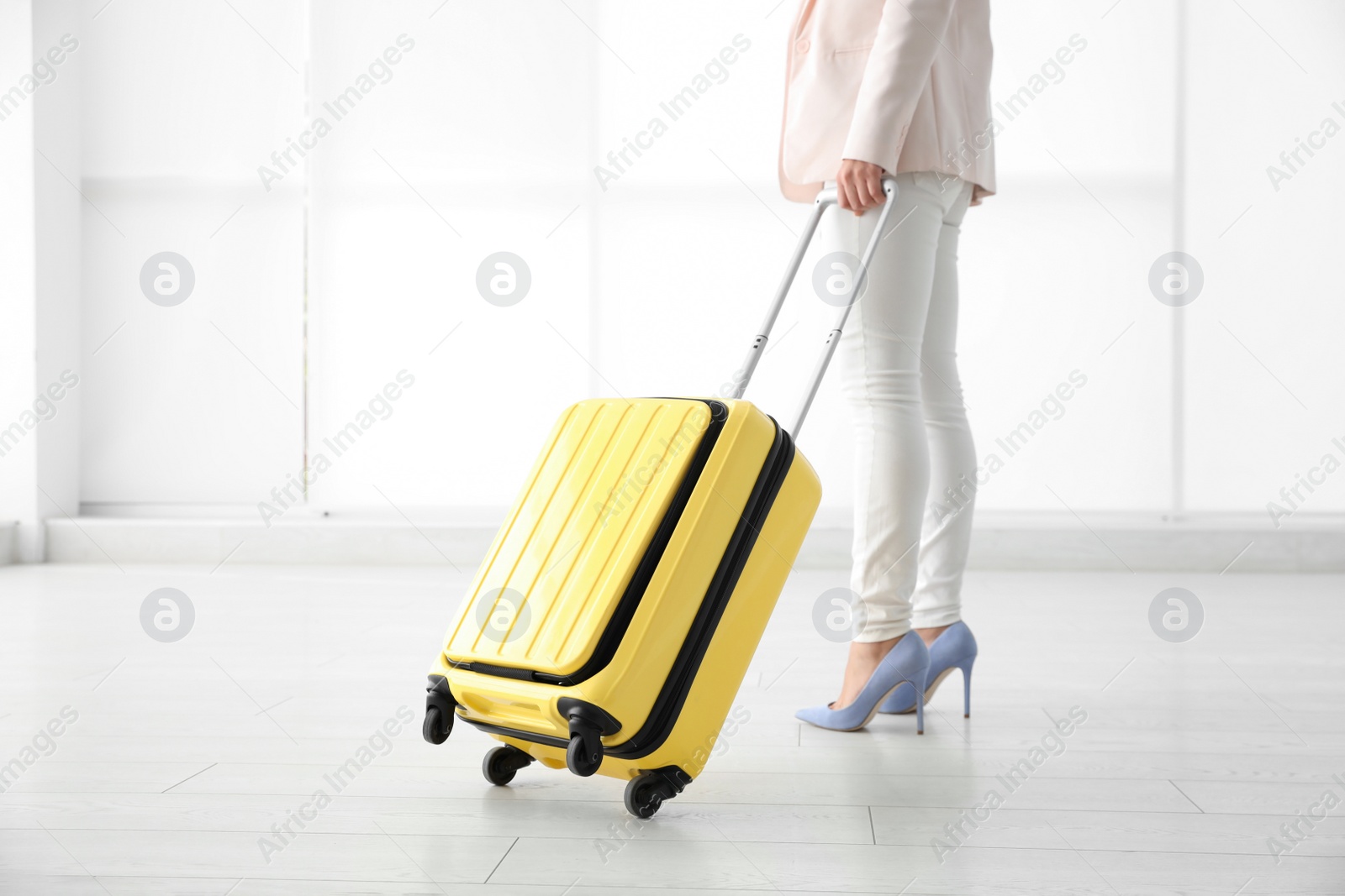 Photo of Businesswoman with yellow travel suitcase in airport