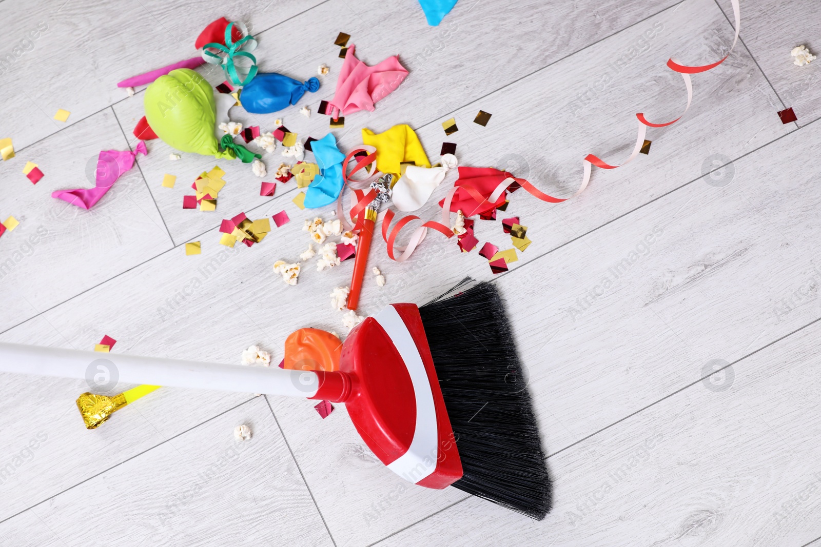 Photo of Sweeping trash after party with bristle broom indoors