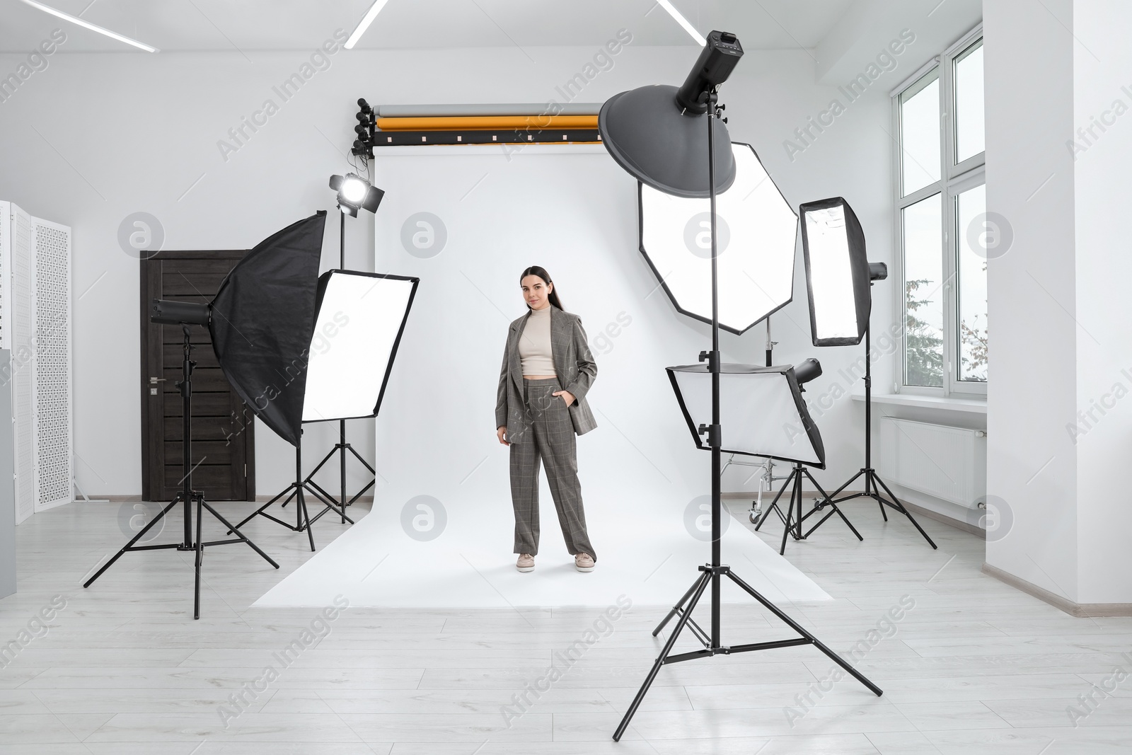 Photo of Beautiful young model posing in modern studio. Professional photo session