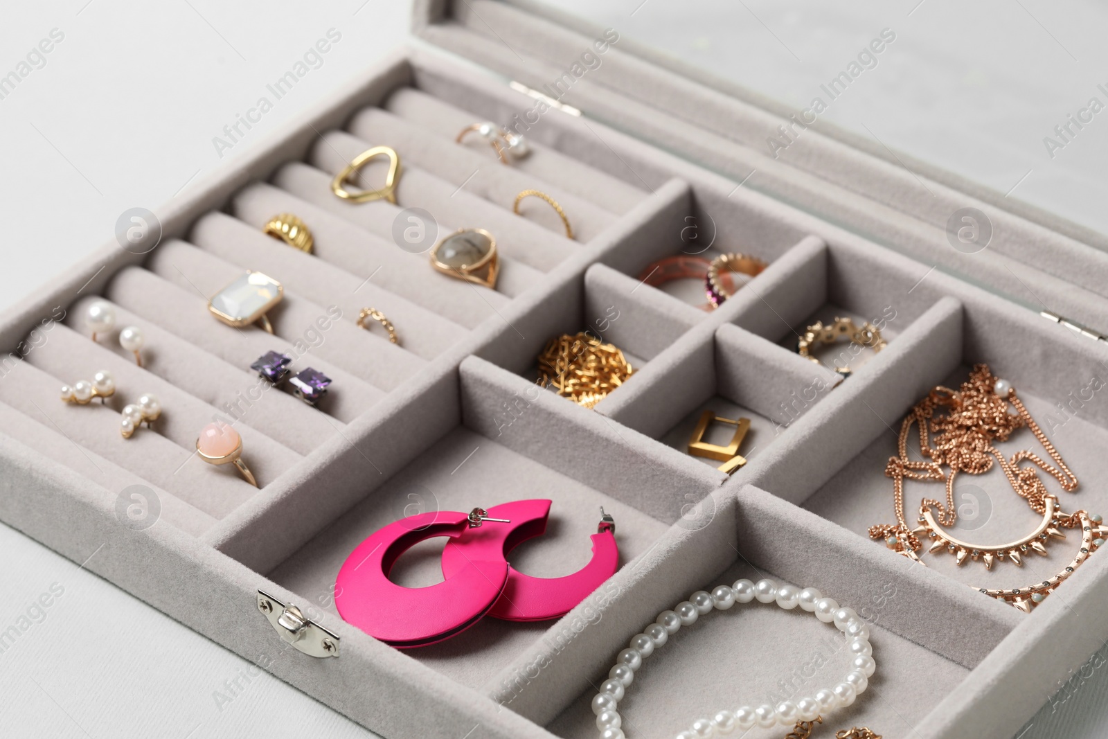 Photo of Jewelry box with many different accessories on light background, closeup