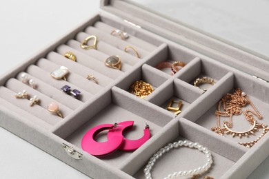 Photo of Jewelry box with many different accessories on light background, closeup