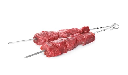 Metal skewers with raw meat on white background