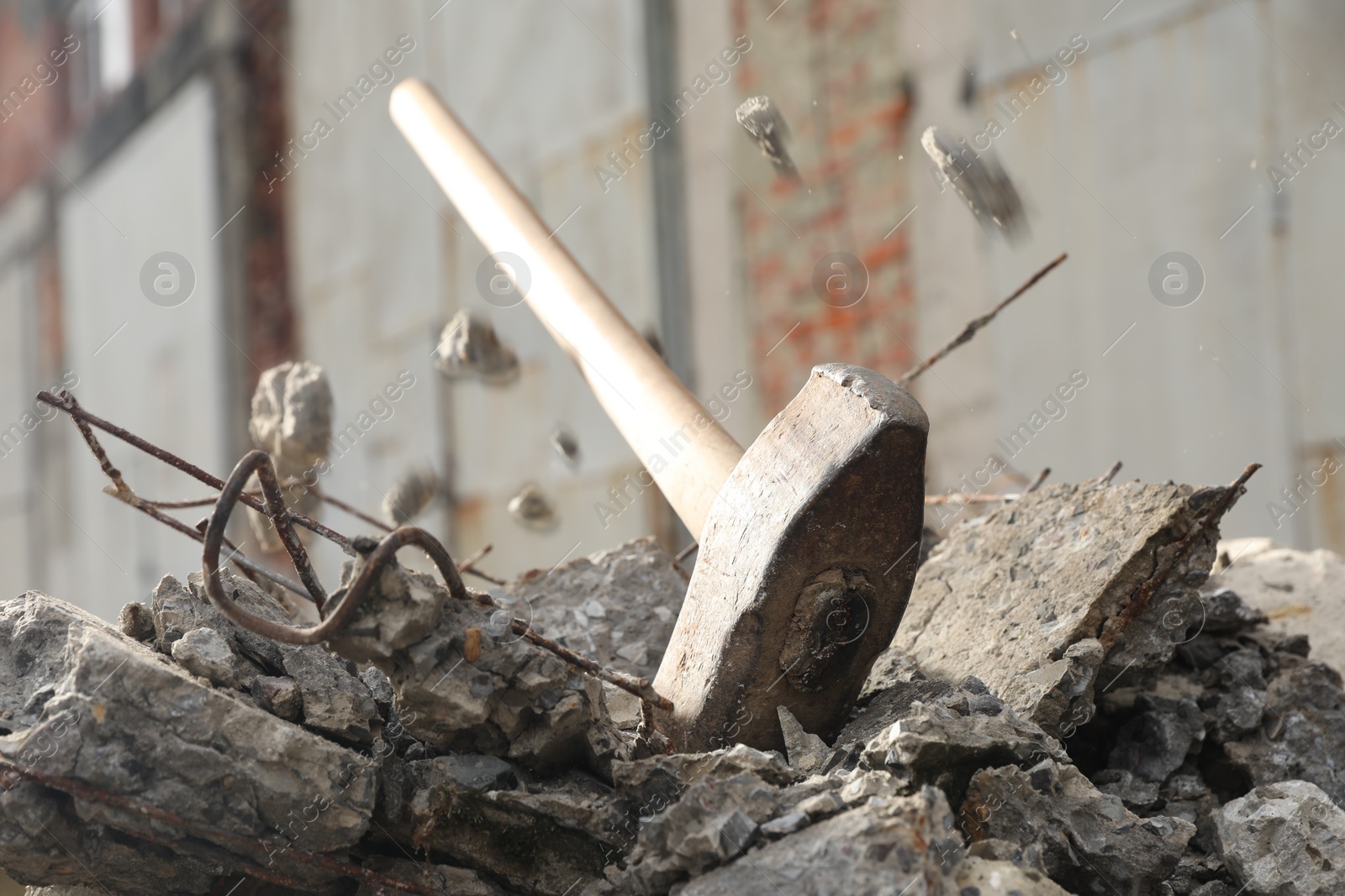 Photo of Sledgehammer on pile of broken stones outdoors, closeup