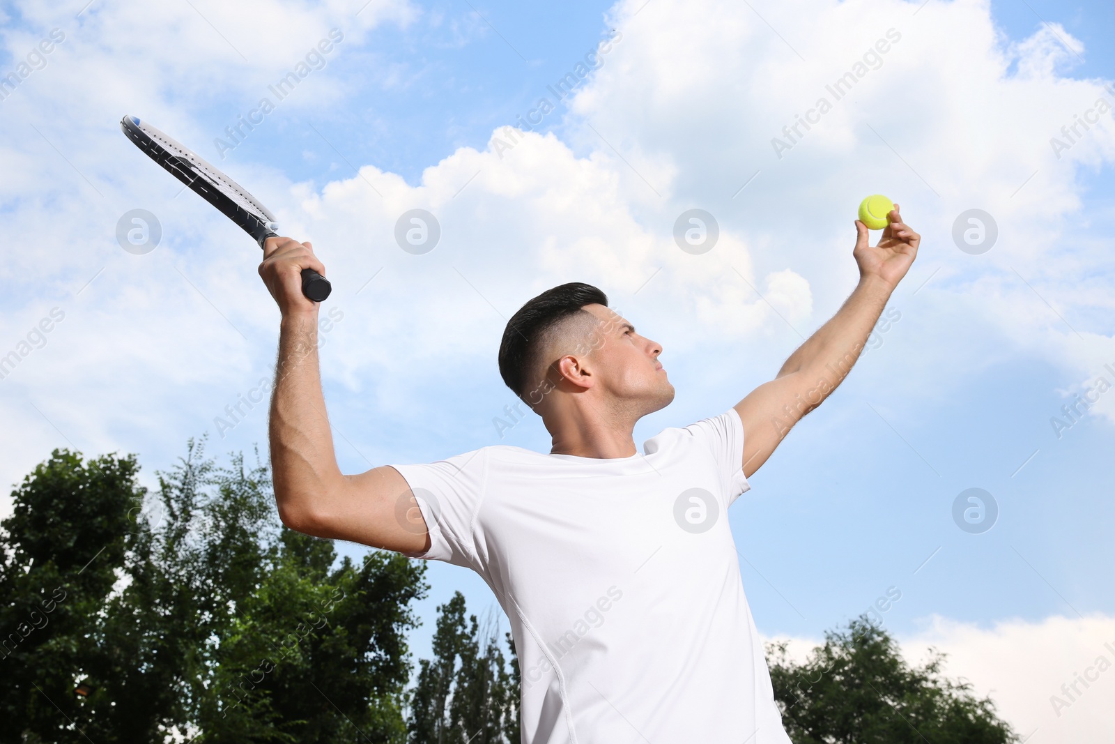 Photo of Man serving ball while playing tennis outdoors