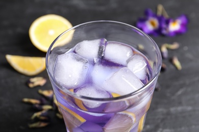 Photo of Organic blue Anchan with lemon in glass on table, closeup. Herbal tea