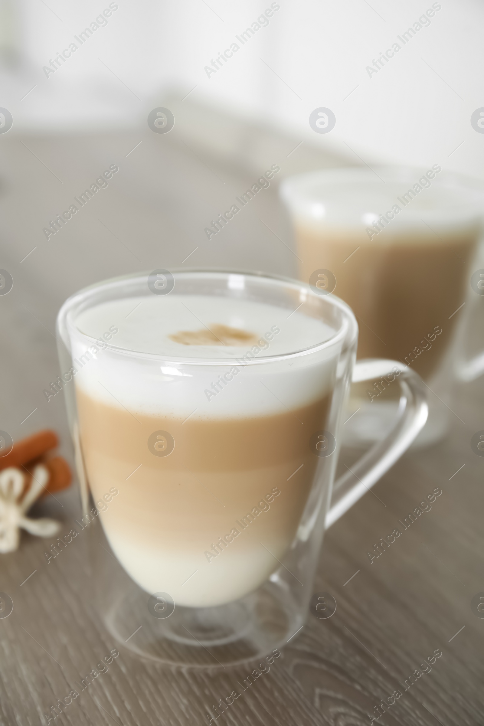 Photo of Delicious latte macchiato in glass cup on wooden table