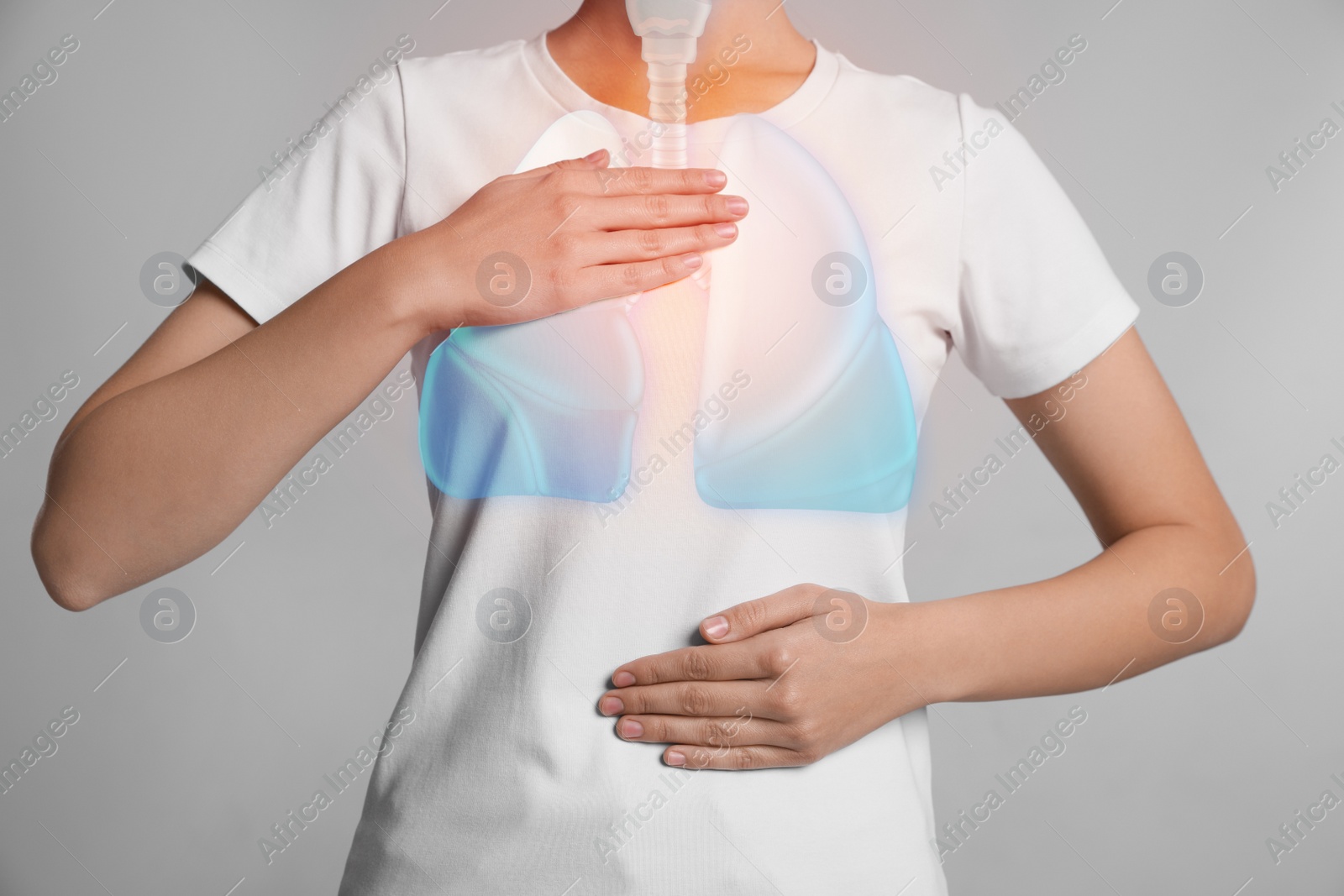 Image of Woman holding hands near chest with illustration of lungs on light grey background, closeup