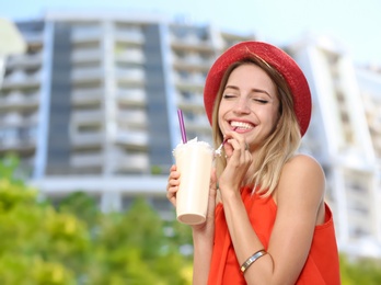 Photo of Beautiful woman with tasty drink on city street