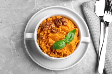 Photo of Tasty sweet potato puree served on grey marble table, top view