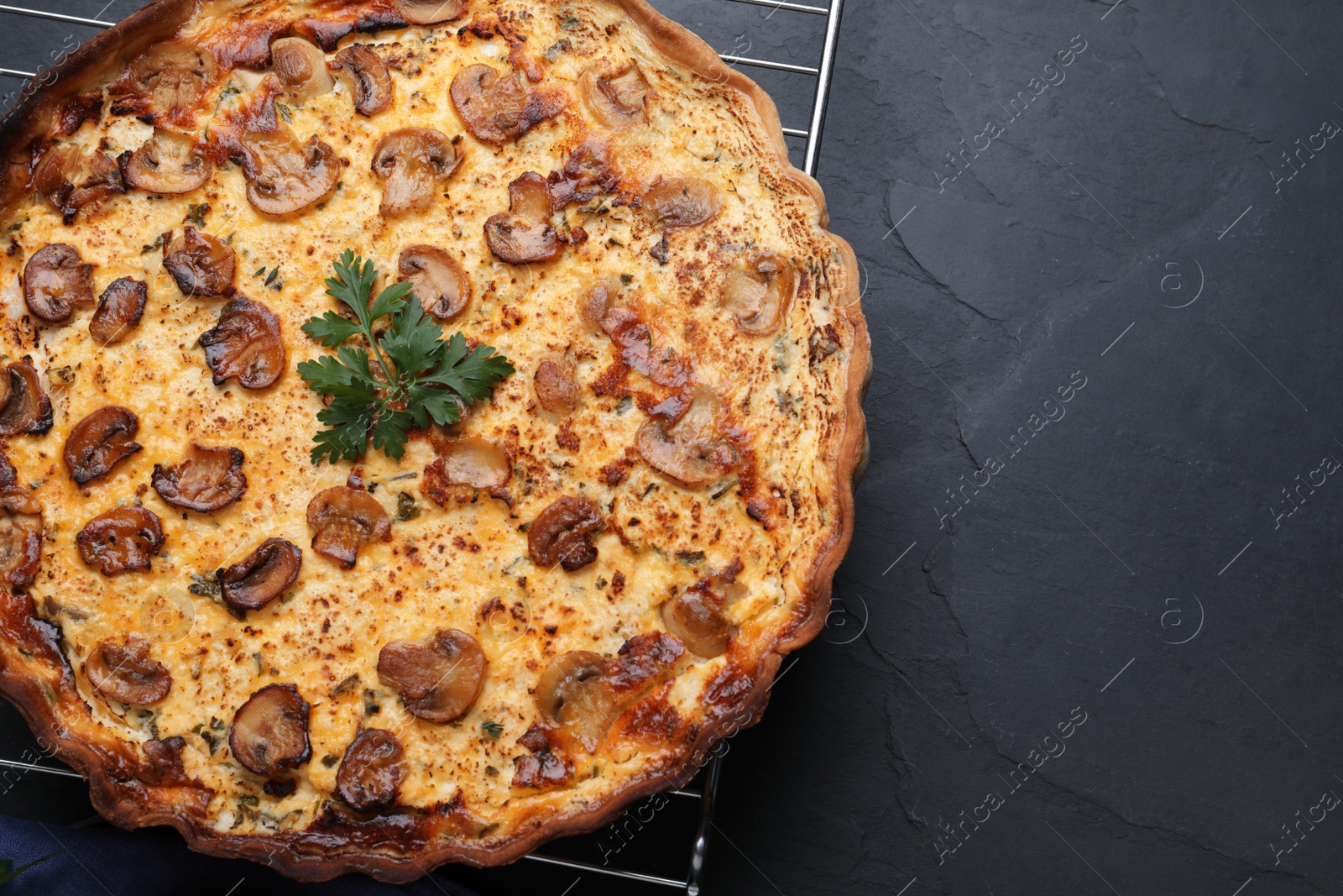 Photo of Delicious homemade mushroom pie on black table, top view. Space for text