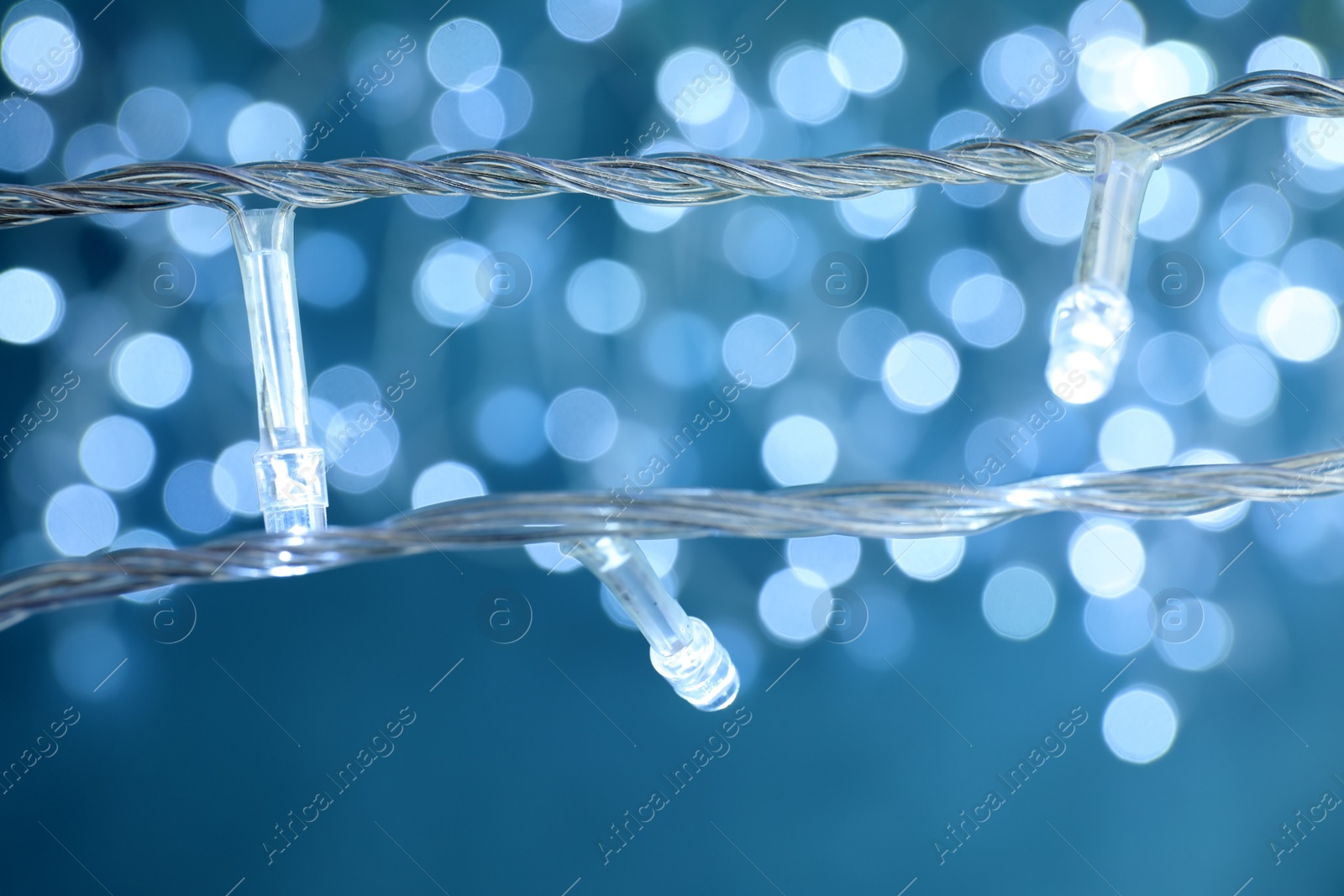 Photo of Beautiful Christmas lights on color background, closeup