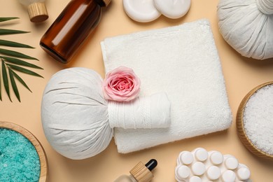 Flat lay composition of herbal bags and spa products on beige background